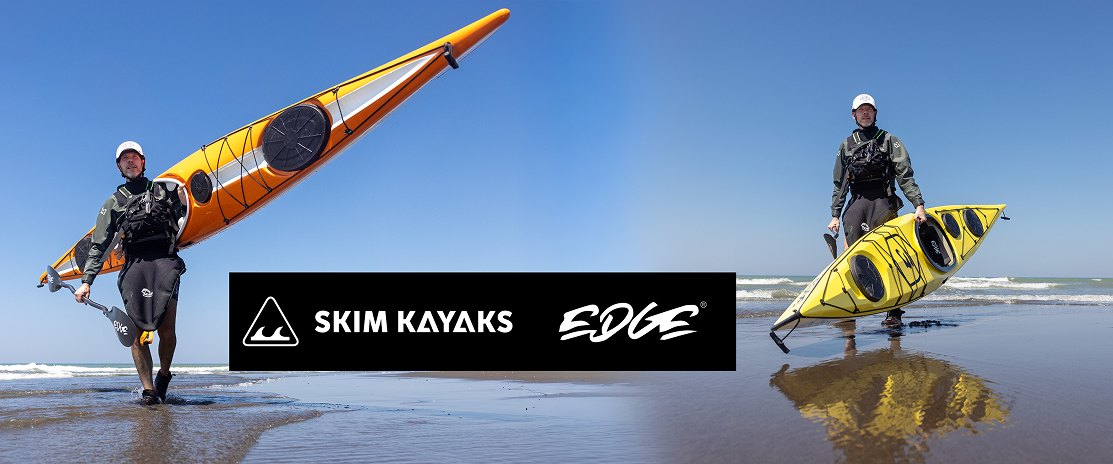 Skim Kayaks and Edge — two paddlers carrying sea kayaks up the beach