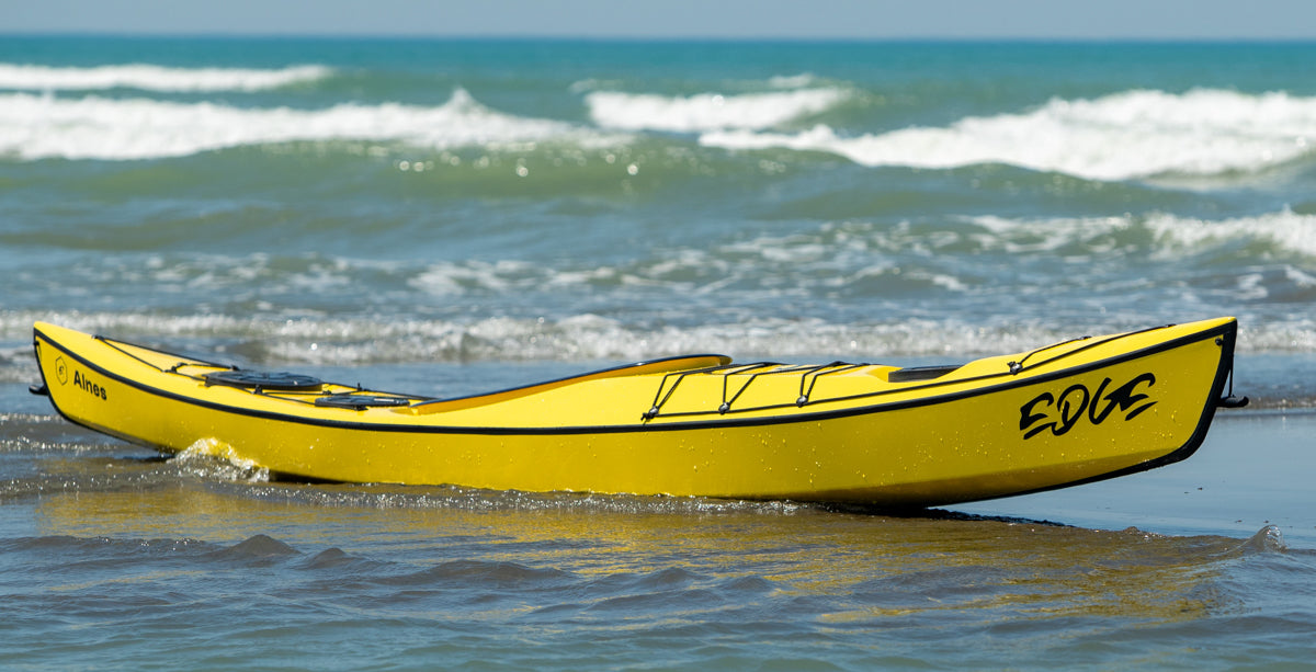 Side profile of a yellow Edge Alnes at the water's edge