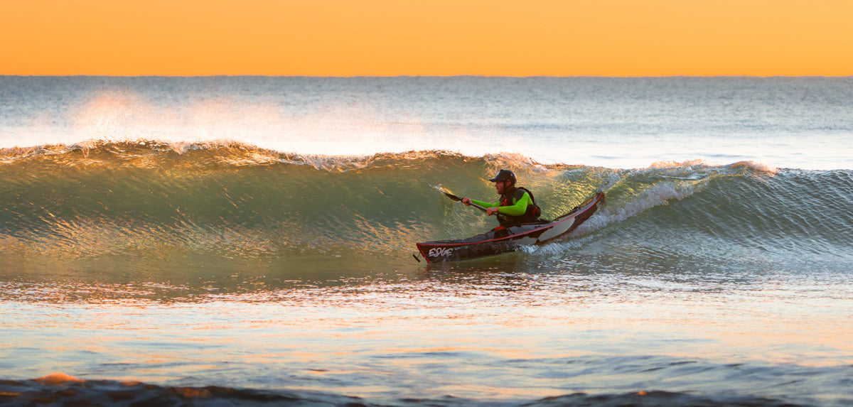 An Edge Alnes surfing a wave at sunset