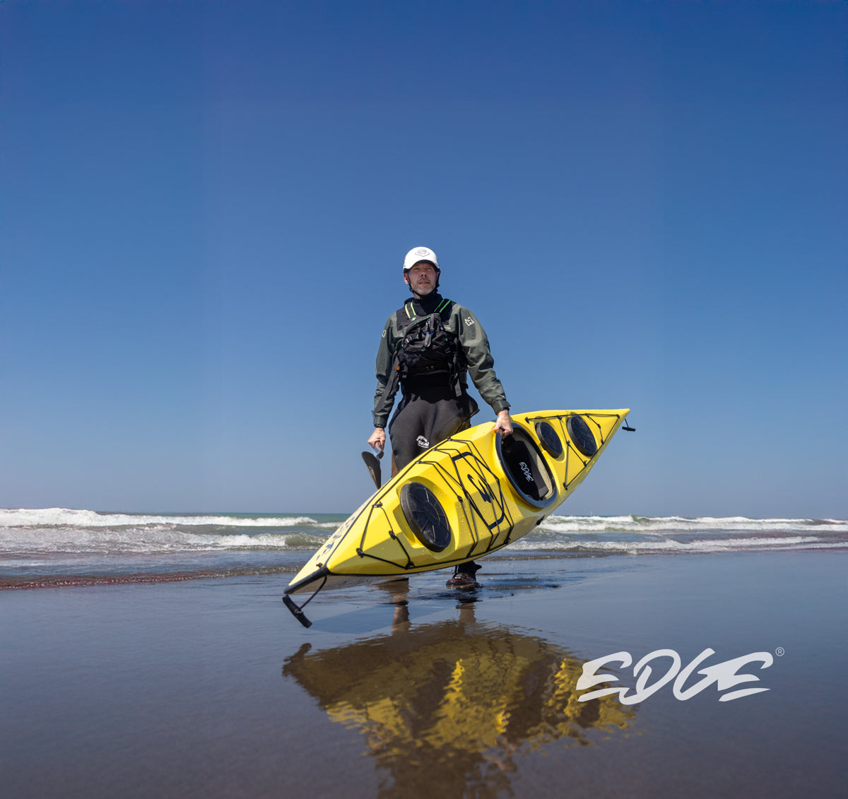 A paddler carrying the Edge Alnes ashore